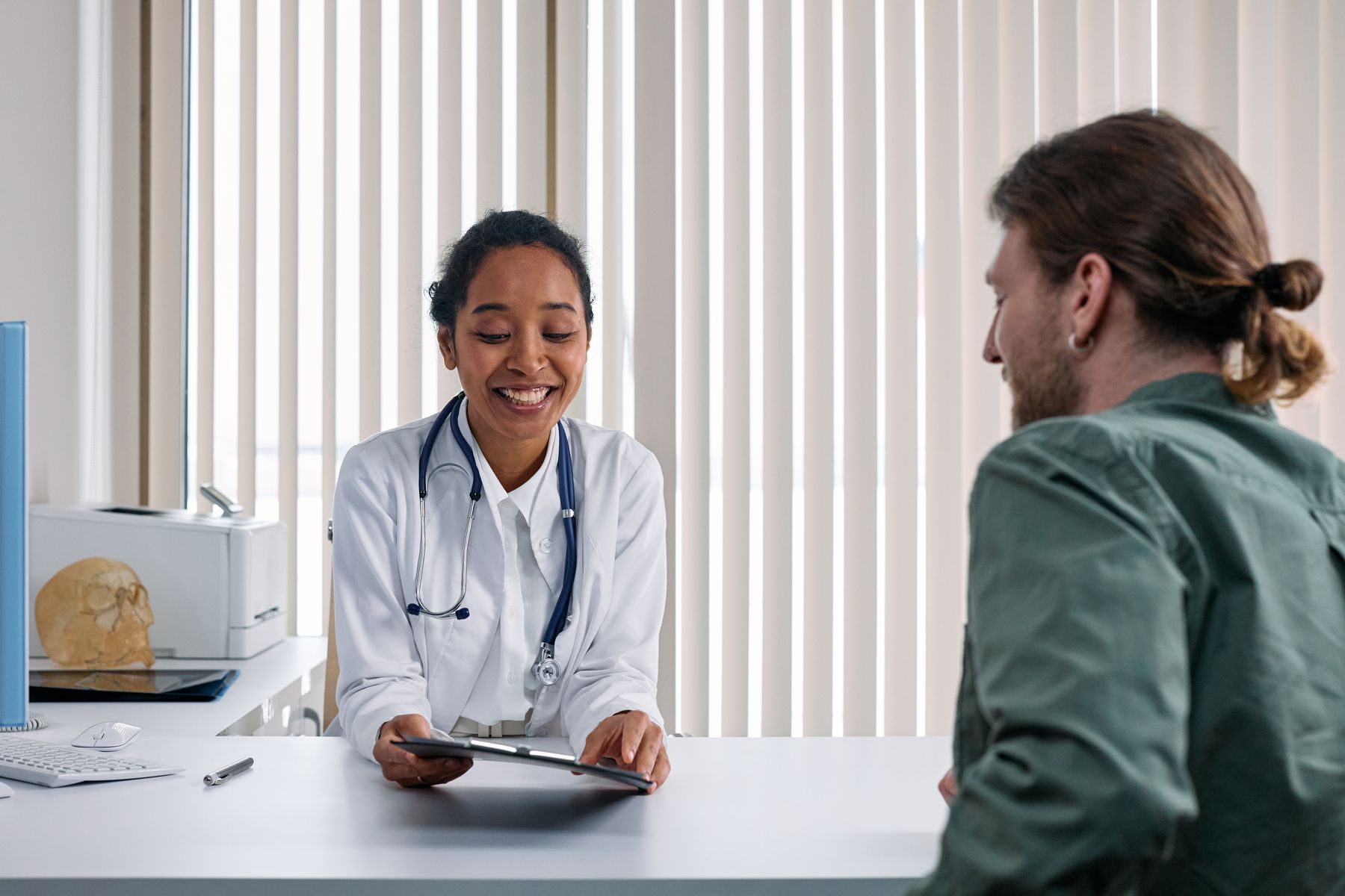 A clinician talking with a patient during a bright, welcoming consultation